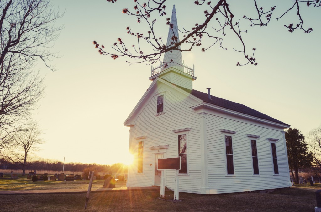 The warm setting sun glows from behind a quaint church in rural Nova Scotia.