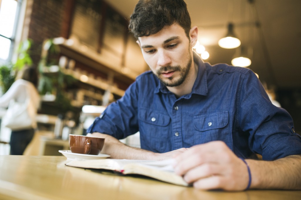 Man Reading Book in Coffee Shop