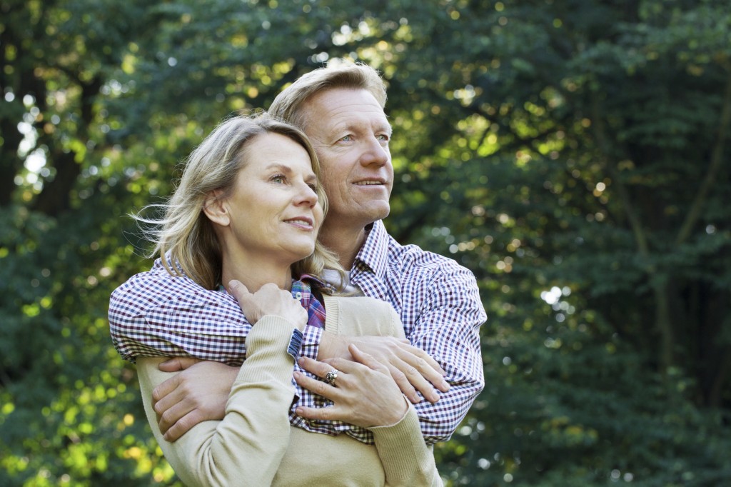 portrait of affectionate mature couple outside in a park looking away