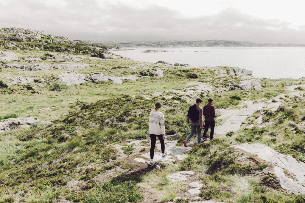 Three young adults walking near the sea in Norway