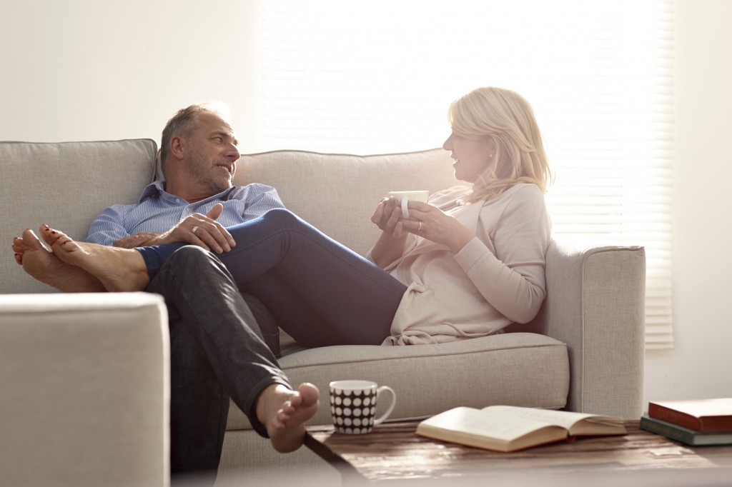 Couple talking in living room with coffee