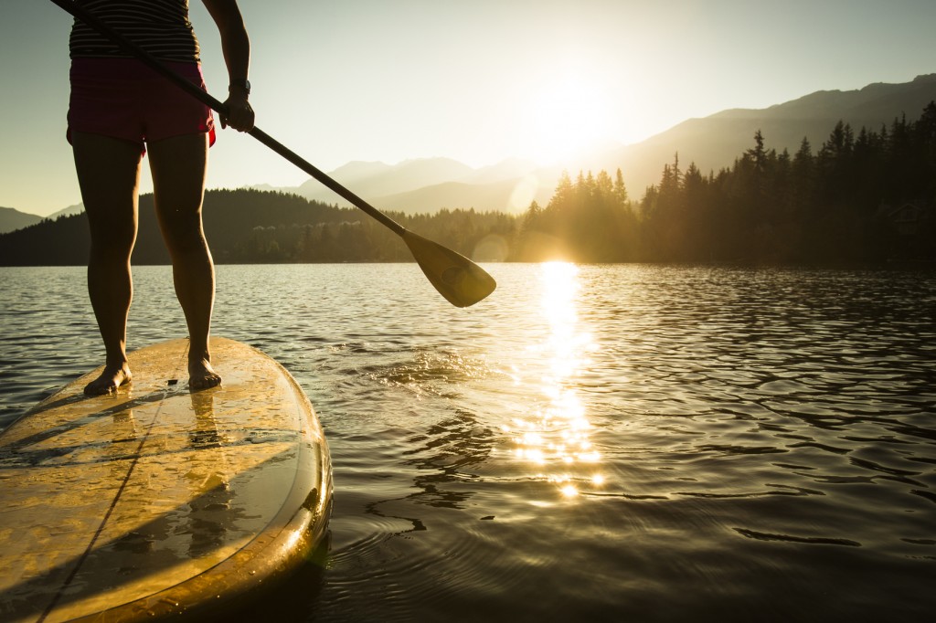 Paddleboarding on lake during sunrise or sunset.