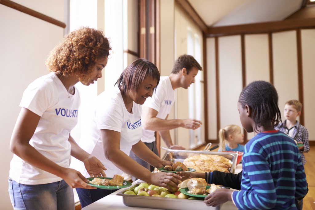 Cropped shot of a group of volunteer workers serving food to children