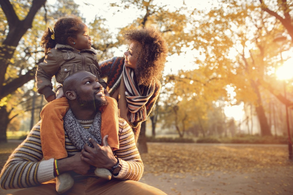 Happy African American family enjoying in nature during autumn.