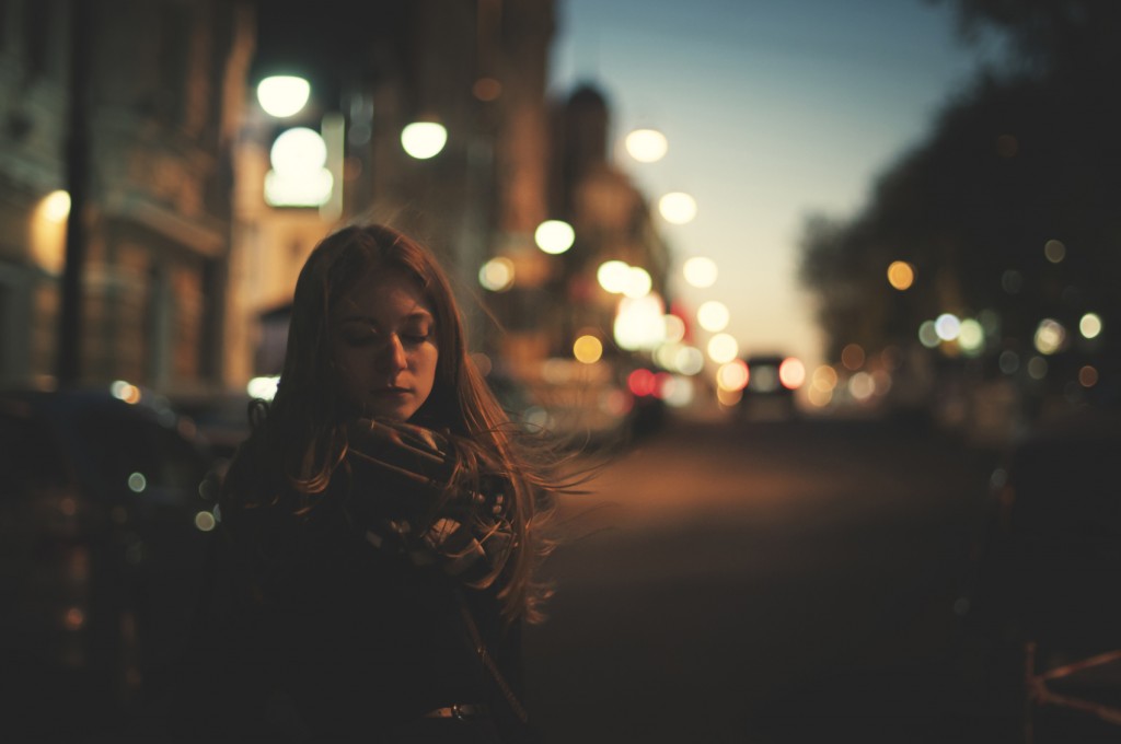 unhappy woman is walking alone on the night street