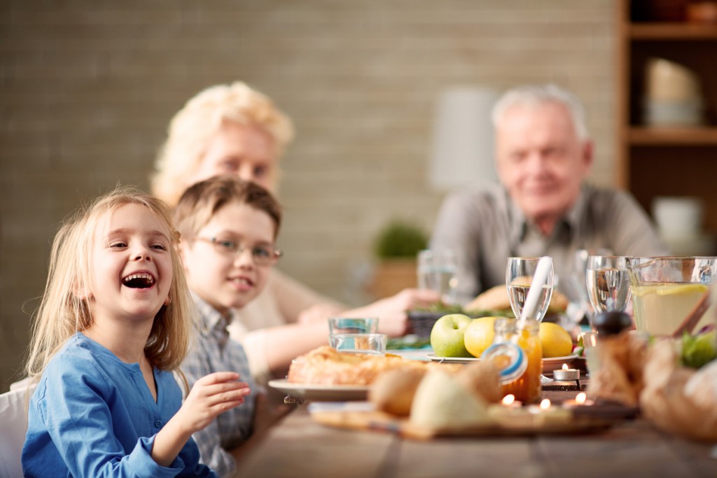 Little girl laughing at multi-generation family dinner