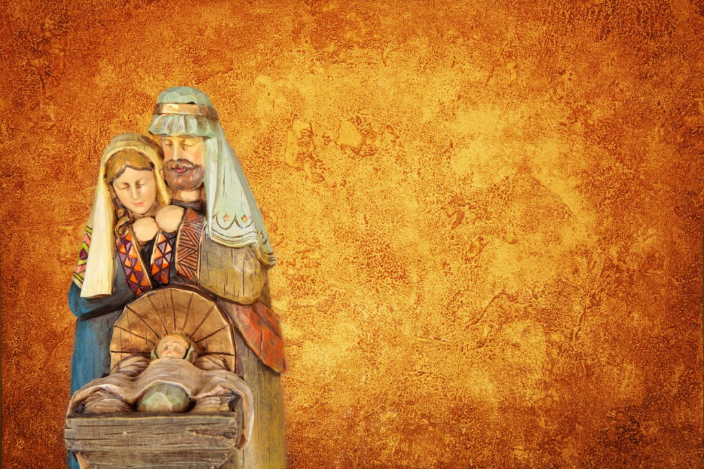 Christmas Nativity with baby Jesus, Mary and Joseph against a textured gold and brown background with ample copy space. Figurines are non copyrighted, made in China items.