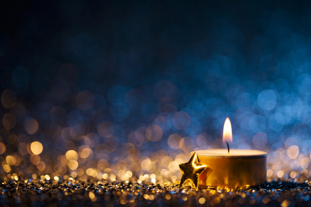 Lighted candle on defocused blue background - Christmas Tea Light