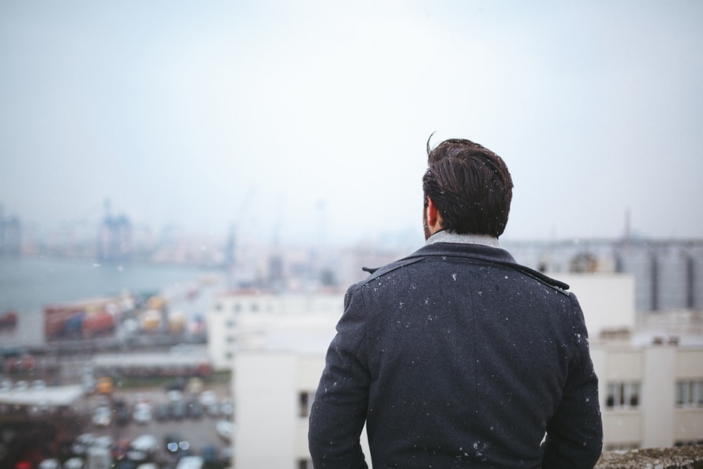 Young adult man standing looking away on a cold day