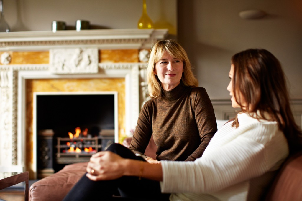 Shot of a woman talking with her mother on the living room sofa