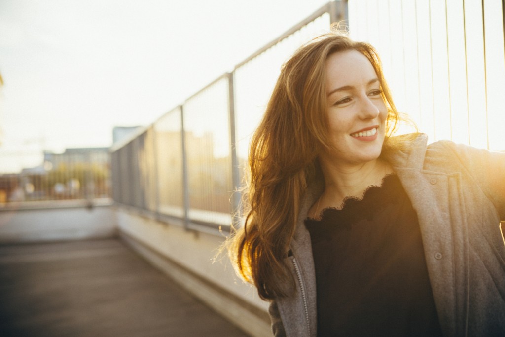 laughing young woman portrait in urban scene with backlit