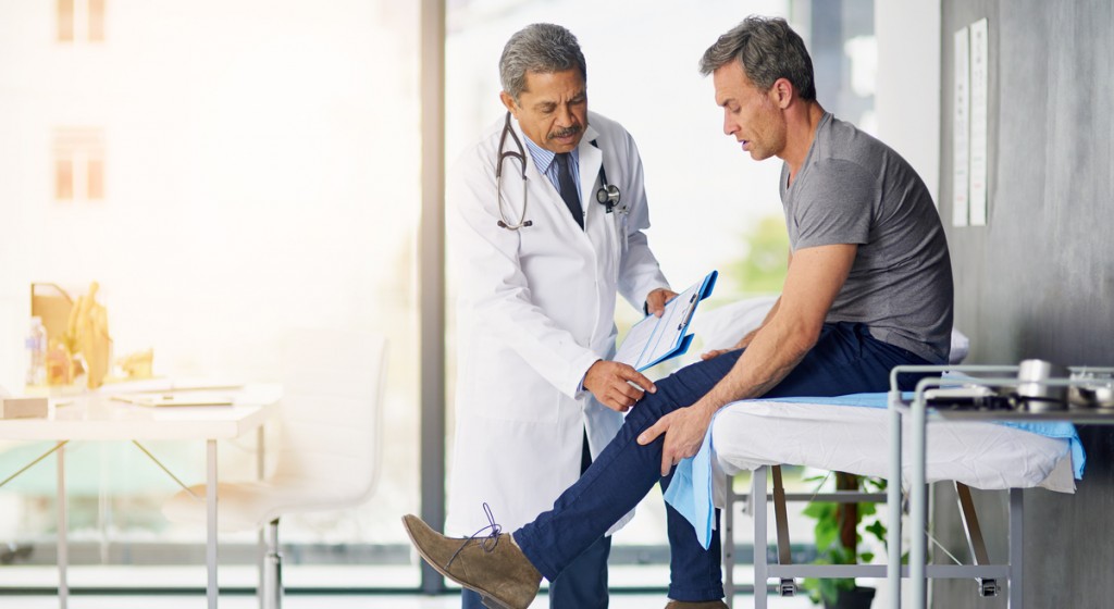 Shot of a mature doctor examining his patient who is concerned about his knee