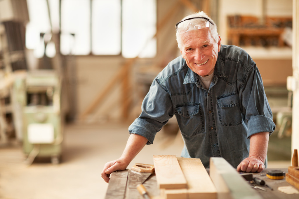 Close up of a smiling mature carpenter at work