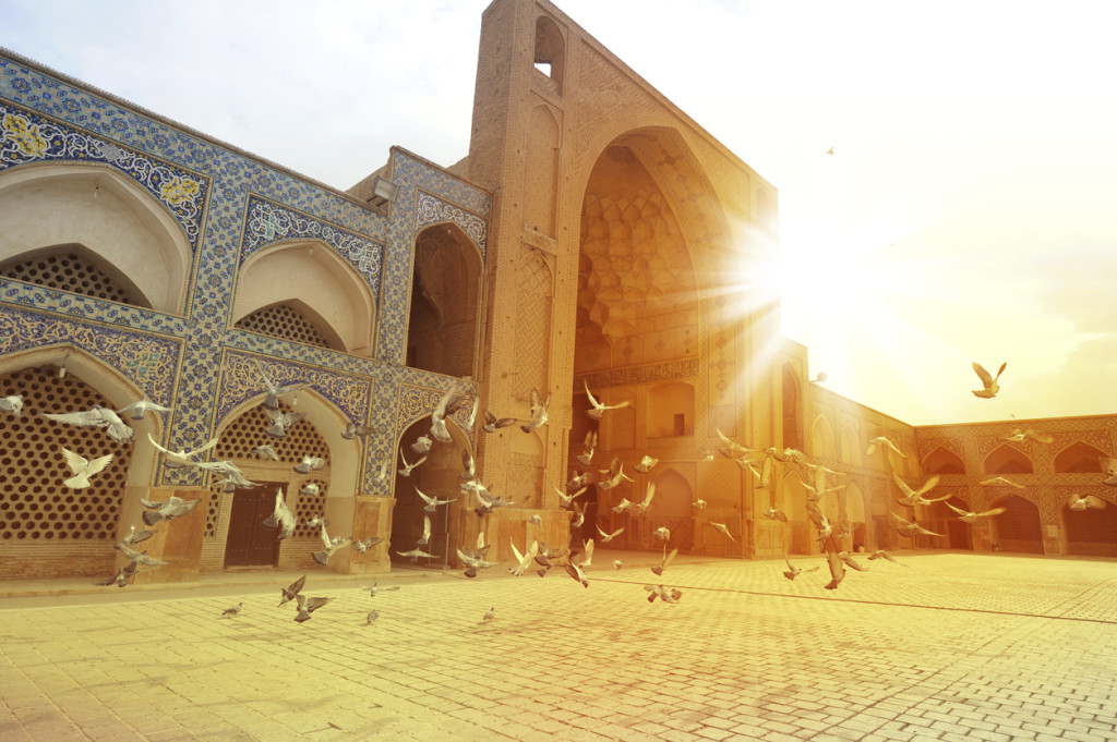 Pigeons in The Masjid-i Jami, Isfahan, Iran. Against sunset background.