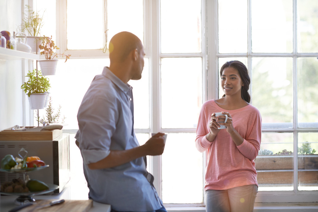 Shot of a young couple talking and drinking coffee in the kitchen