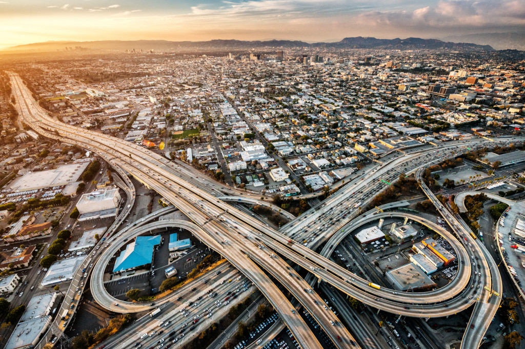 Helicopter point of view of Los Angeles highway interchanges at golden hour. Many details are visible in the image.