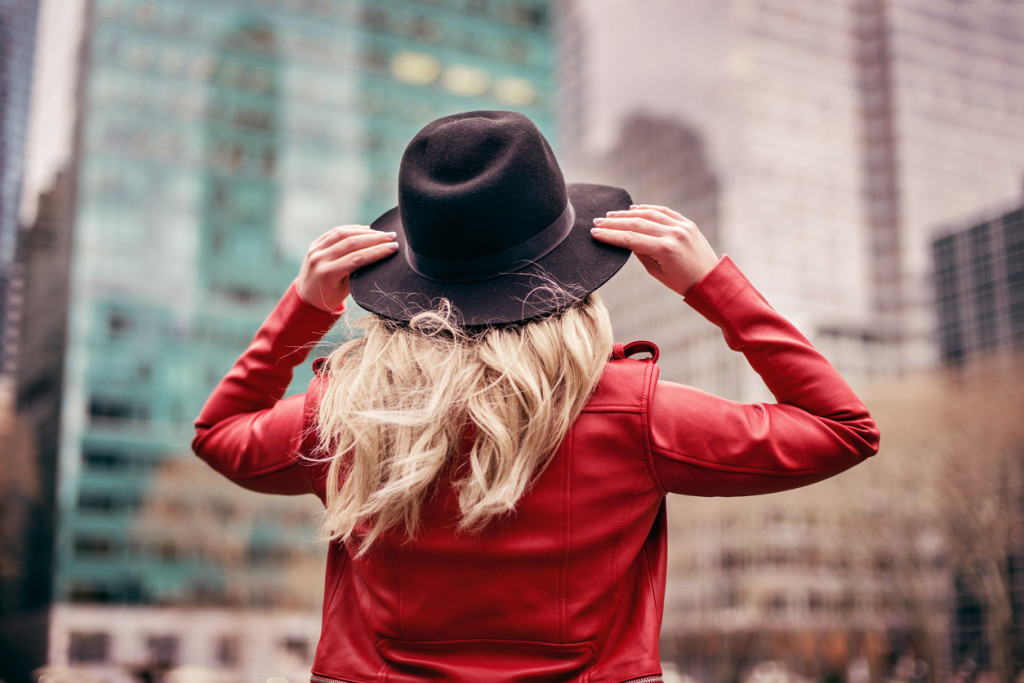 A young woman wearing a hat is walking on the streets of New York City