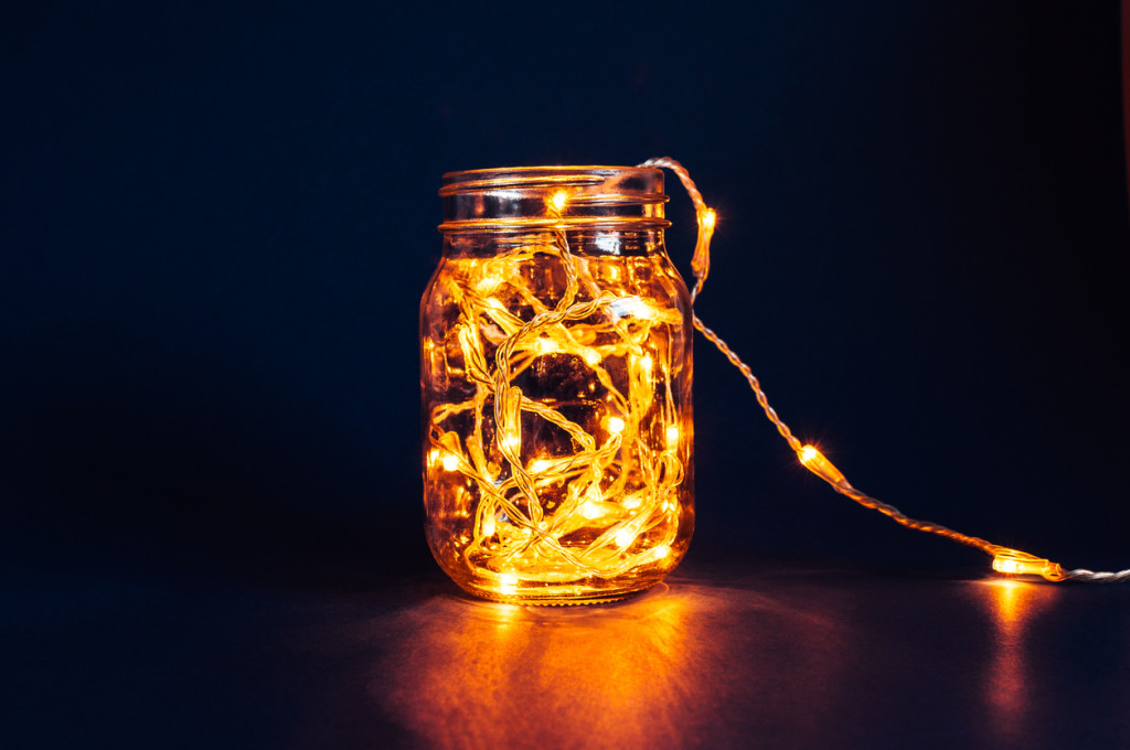 Christmas fairy lights in a mason jar, glowing in the dark