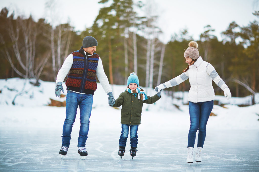 Modern family of father, mother and son skating in natural environment