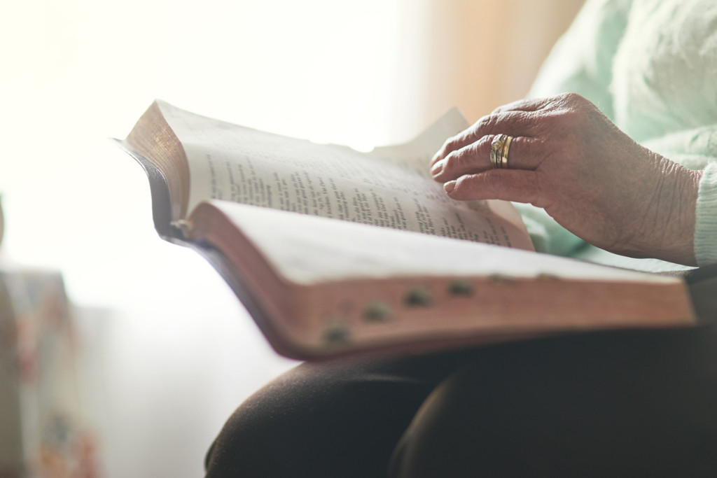 Closeup shot of an unrecognisable woman reading a bible
