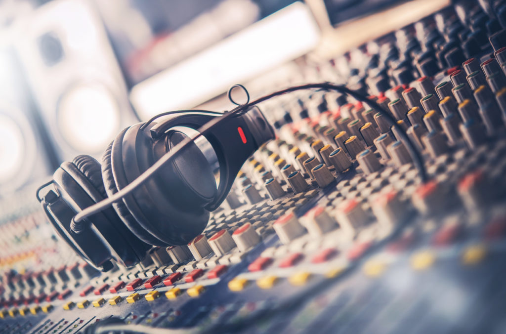 Mixer and Professional Headphones in the Recording Studio. Sound Mixing Desk. Sound Mastering For Radio and TV Broadcast.