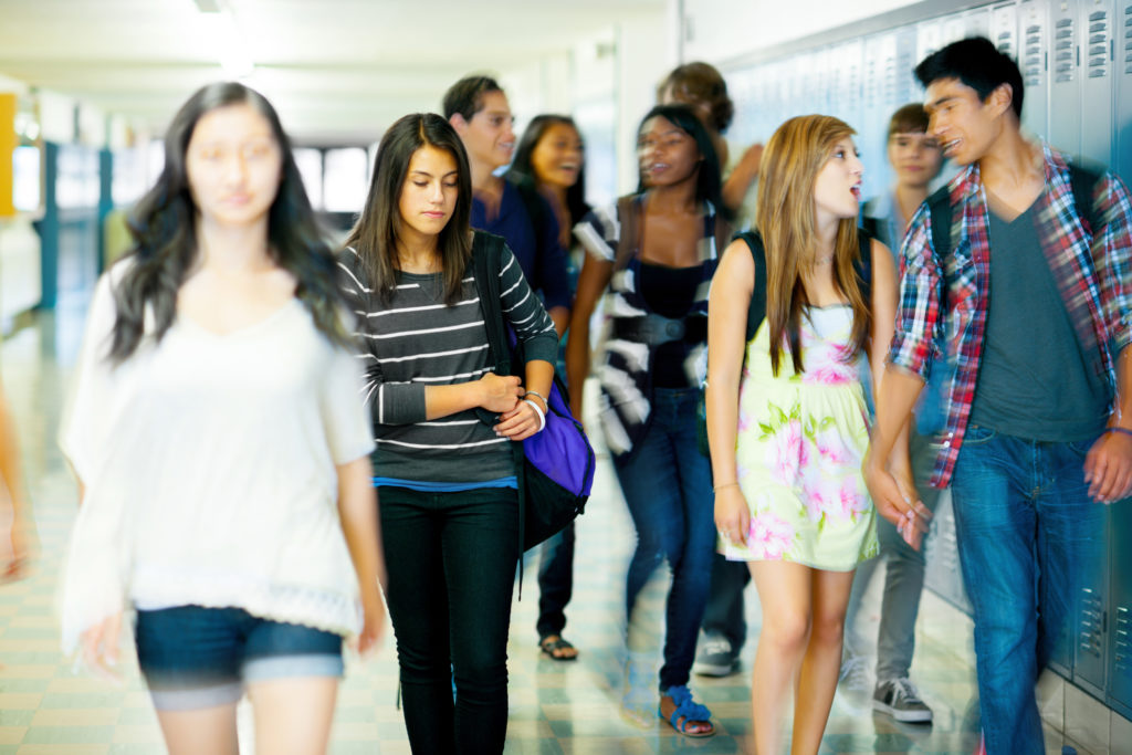 High school students in hallway by lockers.