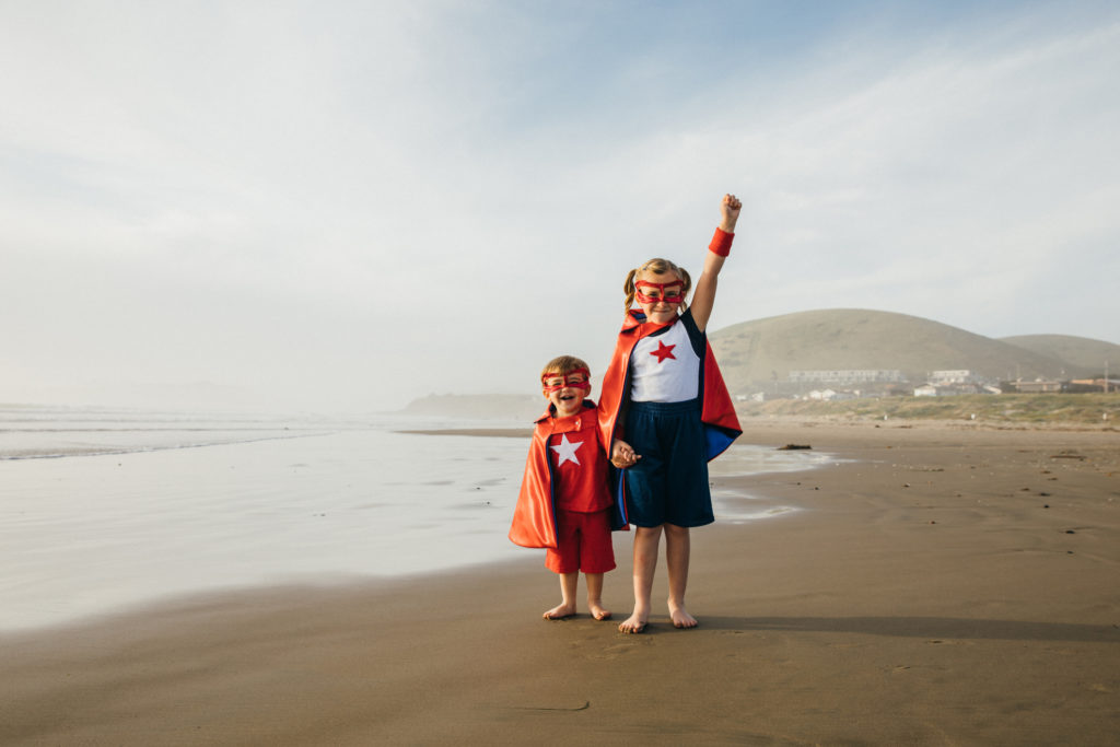 Young Girl and Boy Superheroes on California Beach.