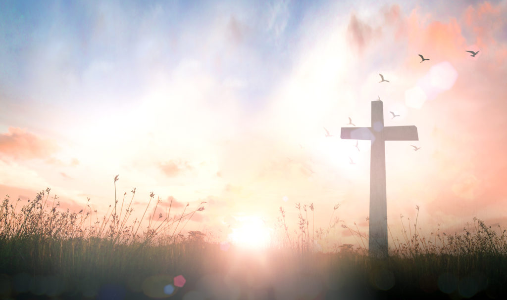 The cross on meadow sunrise background