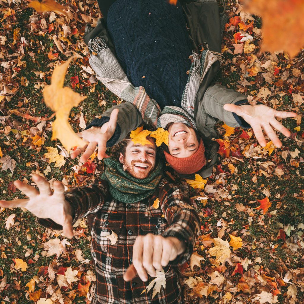 Couple playing in fall leaves