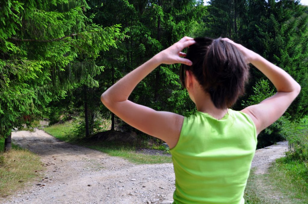 woman overthinking two options on trail