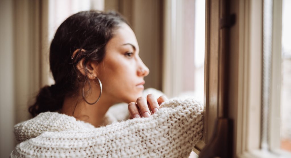 Worried woman looking out window