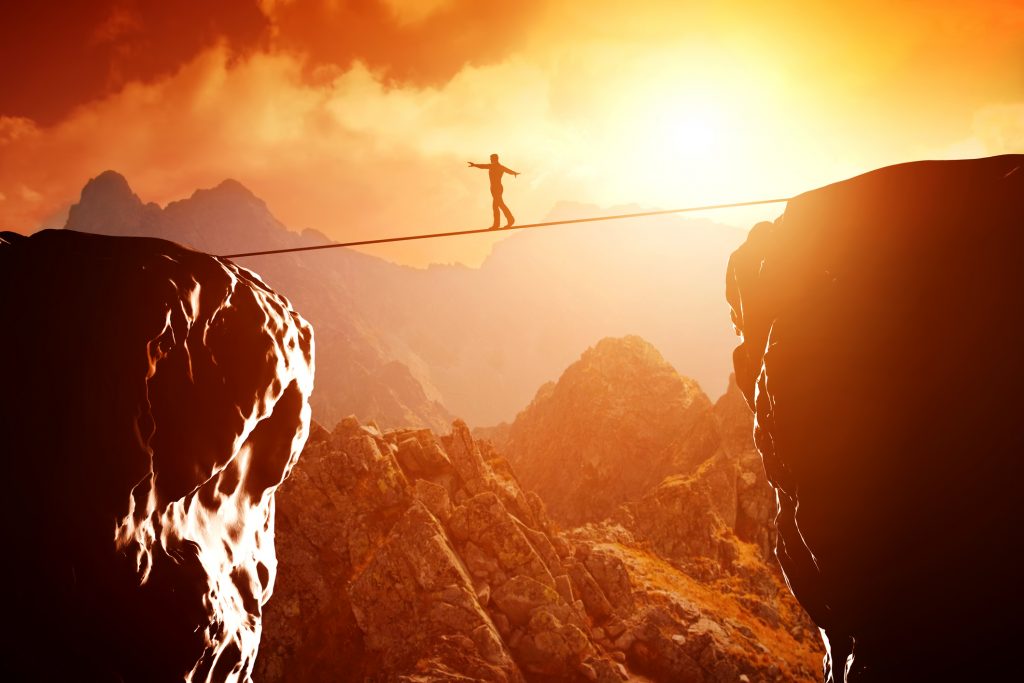 man walking on tension rope over canyon