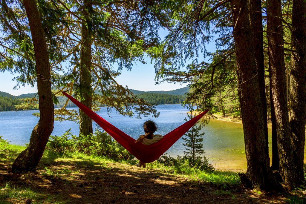 tired girl finding rest in a hammock with a beautiful nature view