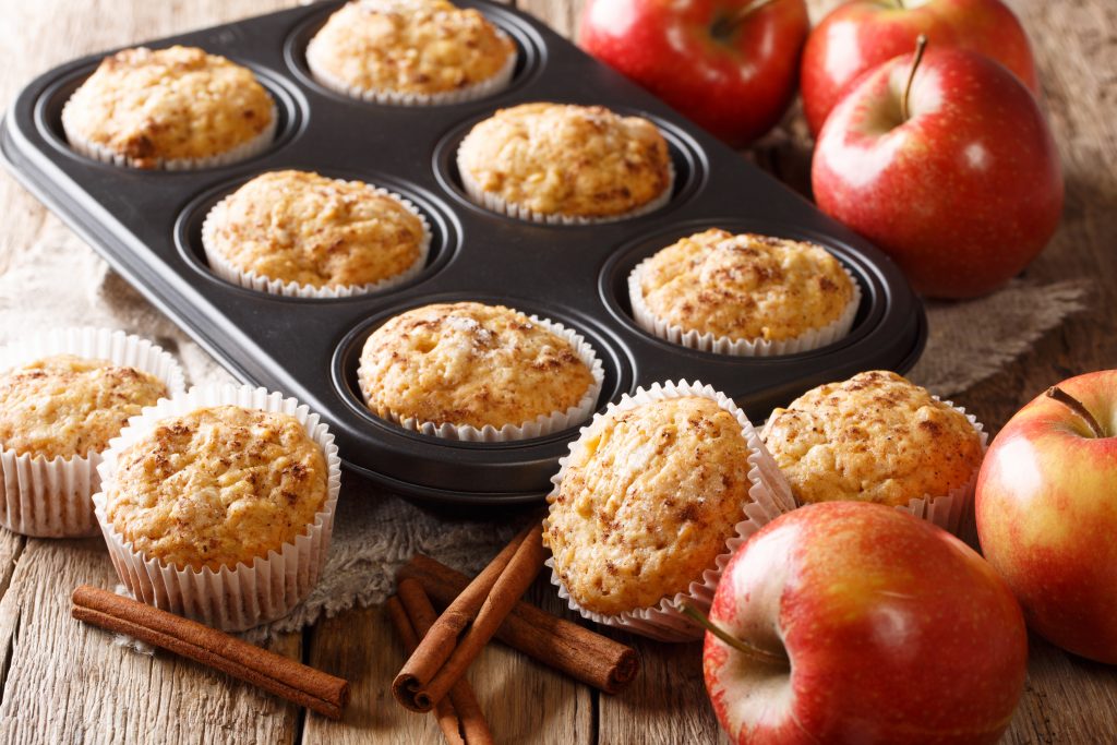 Sweet dessert apple muffins with cinnamon close-up in a baking dish on the table.
