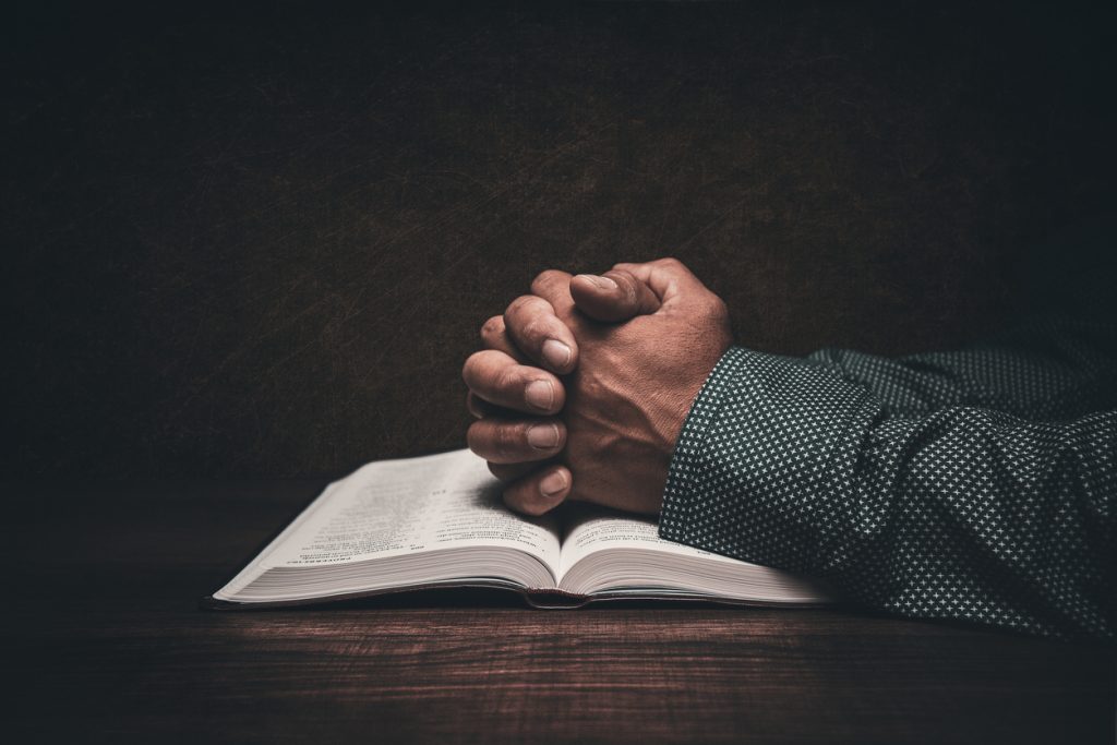 Man praying over bible