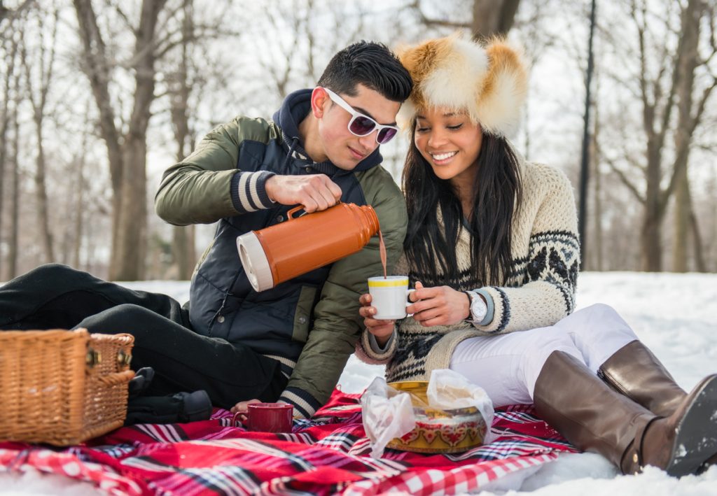 Young couple upping the romance with an outdoor, winter picnic