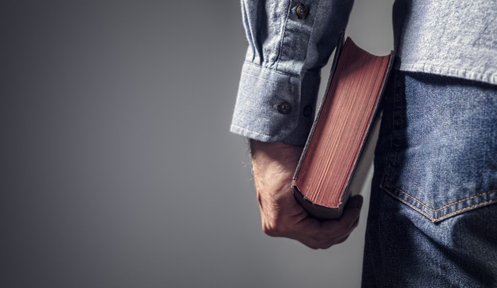 A man holding a Bible at his side