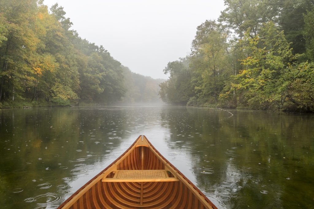 Bow of a cedar canoe on a river during a light rain - Ontario, Canada