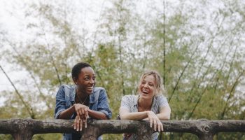 A couple of women friends laughing together outside
